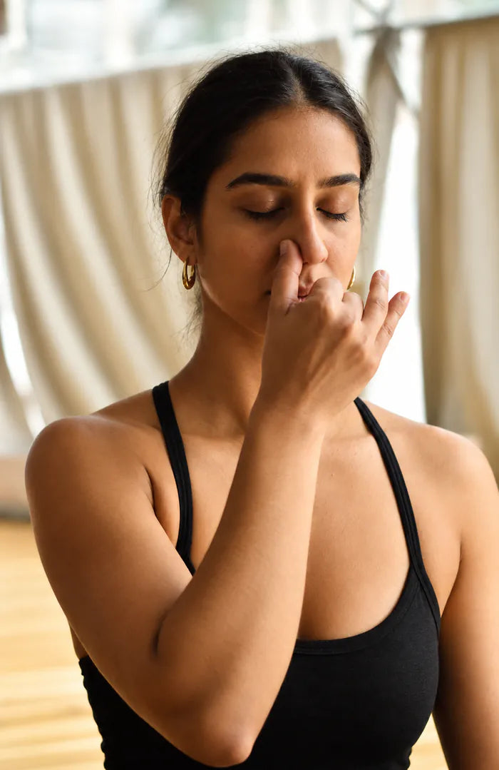 A woman practising alternate-nostril breathing