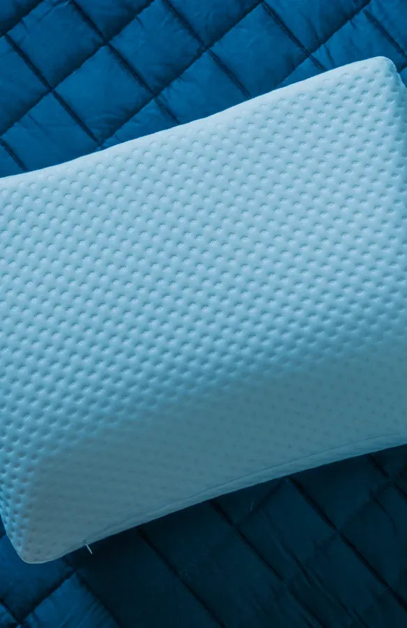 An AIWO contoured head pillow on a quilted blue surface