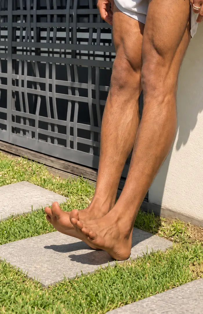 A person’s lower legs mid-exercise on a garden path