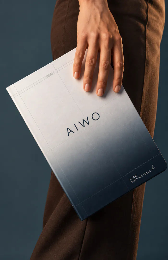 A hand holding a printed AIWO protocol booklet